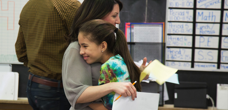 Chapel Hill Academy female student and teacher embracing