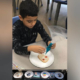 Elementary student making Dia del los Muertos cookies in world language class