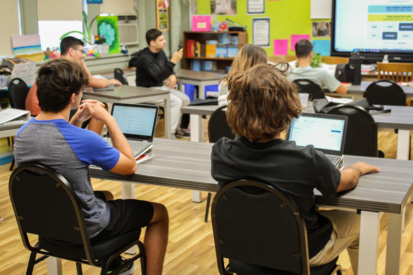 two high school boys working at computers in classsroom